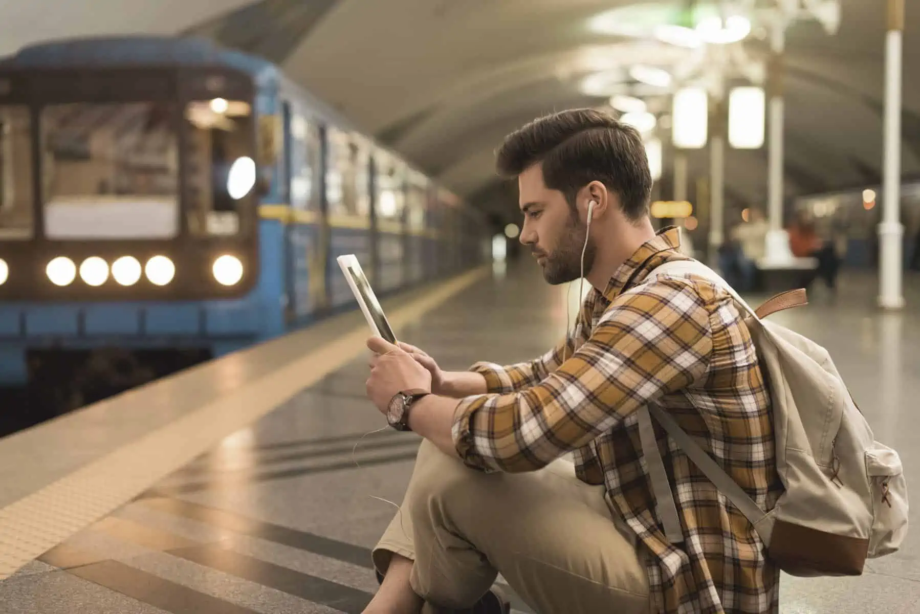 autofi-blog-man-on-device-train-station